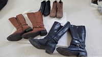 Four pairs of ladies' boots displayed on carpet, two ankle boots at back and two high boots at front.