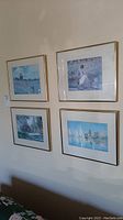 Four framed prints arranged on a wall showing the variety of scenes in the lot