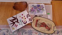 Overview of all four items laid out on floor: wooden bowl, Starbucks tray with abstract floral, floral ceramic tray, and Vermont souvenir tray