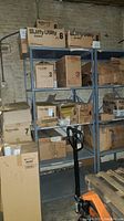 Metal shelving unit loaded with cardboard boxes of Jiffy Utility mailers and Quality Park mailing tubes