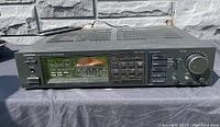 Front view of Onkyo Tuner Amplifier TX-2500 showing control panel with tuning dial, level meter, input selectors, and other buttons.