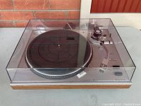 Front left angle showing wood base, dust cover closed, control panel visible