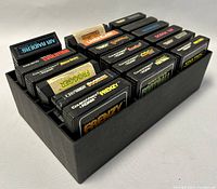 Photo showing 18 vintage ColecoVision and Adam computer system video game cartridges neatly organized in a black container.