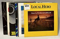 Photo of vinyl album covers including 'Local Hero' by Mark Knopfler and several others stacked showing edges and spines