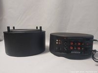 Side view of the subwoofer body and its top with connector pins.