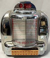 Front view of the Crosley novelty jukebox cassette player showing chrome finish, song selection list, and buttons A-K and 1-10.