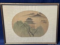 Framed vintage Chinese watercolour painting on silk, showing traditional pagoda and willow trees with mountains behind, oval composition, mounted on decorative silk brocade matting.