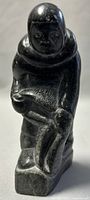 Front view of the soapstone Inuit hunter holding a seal bladder showing facial features and body posture.