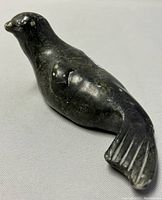 Soapstone seal carving from side showing surface wear and natural stone texture.