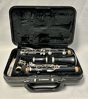 Disassembled vintage Yamaha clarinet in black hard case with velvet lining.