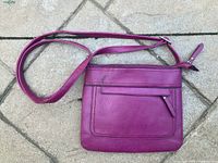 Full view of purple crossbody handbag showing shape, strap, and front pocket.