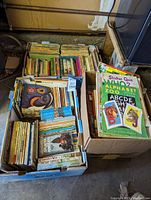 Top view of three boxes filled with children's books including picture books and chapter books