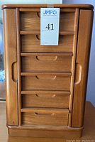 Front view of the closed wooden jewelry box with label.
