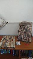 Two ceramic Egyptian art tablets on display, showing detailed ancient Egyptian figures and hieroglyphics.