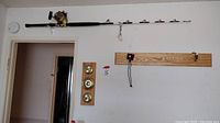 Wood wall shelf with multiple hooks attached to wall.