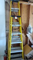 Full view of the 8-foot yellow Keller fiberglass ladder showing steps, side rails and top black platform.