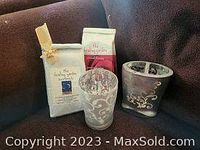 Photo of two packages of Healing Garden Bath Salts, one white and one pink, alongside a glass holder and a toothbrush holder with silver pattern.