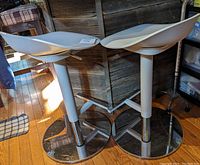 Pair of grey IKEA Janinge adjustable bar stools showing seats and bases.