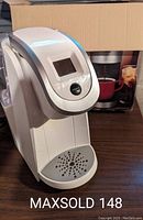 White Keurig K200 coffee maker front view showing the digital display and drip tray.