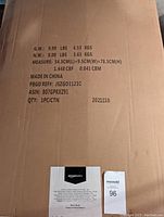 Box of Amazon Basics Premium Folding Portable Soft Pet Crate showing product weight, dimensions, and manufacturing details.