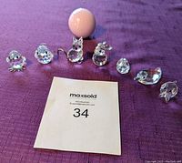 Photo showing all six Swarovski crystal animal figurines arranged in a row alongside a golf ball for size comparison.