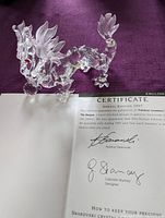 Crystal dragon figurine displayed with certificate of authenticity showing signatures and details of annual edition 1997.