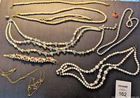 Full view of all jewelry items spread on a surface including necklaces, bracelets, and chains.