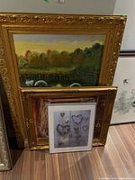 Wide-angle shot of all four framed art pieces stacked against a wall