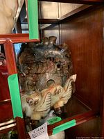 Photo of large Asian metal fish wall sculpture and two cream resin elephant figurines with brown detailing.