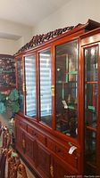 Front view of complete buffet and hutch set showing mahogany finish, glass doors and carved top crest