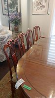 Four carved wood dining chairs around wood table showing overall lot