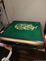 Full view of table top with green felt and scattered mahjong tiles