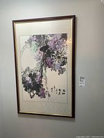 Full view of the framed and matted art print on the wall showing purple grapes and calligraphy.
