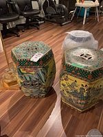 Pair of hexagonal ceramic stools with pierced tops and hand-painted decorations