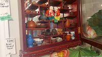 Display shelf showing porcelain figurines, teapots and bowls