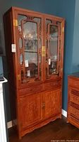 Full front view of the carved wood display cabinet