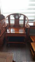 Front view of wood armchair showing carved backrest and flat seat