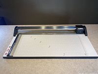 Front angled view of the full professional paper cutter showing the grid surface and cutting mechanism.
