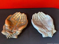 Pair of vintage hand dishes, one bronze and one silver aluminum, shown on a red background
