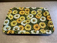 Top-down view of the rectangular folding tray featuring daisy flower print on green background.
