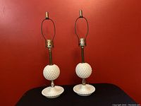 Pair of vintage hobnail milkglass boudoir lamps with brass hardware and round textured milkglass globes.