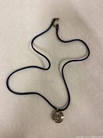 Full view of the navy cord necklace laid out flat, showing length and clasp.