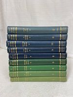 Books stacked horizontally showing spines with gold embossing listing volumes 2-4, 6, 8-12 of My Book House series.