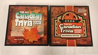 Two boxed Canadian trivia board games side by side, the standard edition and the 2000 millennium edition, showing front cover art.