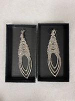 Pair of sparkling long earrings inside a black display box
