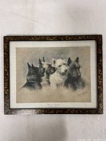Full view of framed art depicting four terriers by Fannie Moody with mottled dark and gold frame.