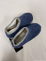 Top view of blue polyester Snoozies slippers showing white trim and toe shape