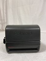 Front view of black Polaroid One Step Close Up camera with 'Polaroid' embossed on the flash cover.