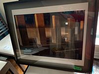 Framed photographic art featuring vertical wooden beams with shadows and reflections, showing artist signature and date on matte.