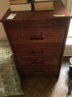 Front view of the wood four drawer cabinet showing the full cabinet and recessed handles on drawers